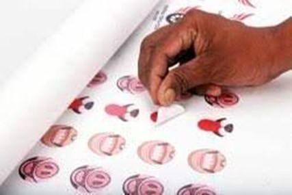 A hand peeling a sticker paper
